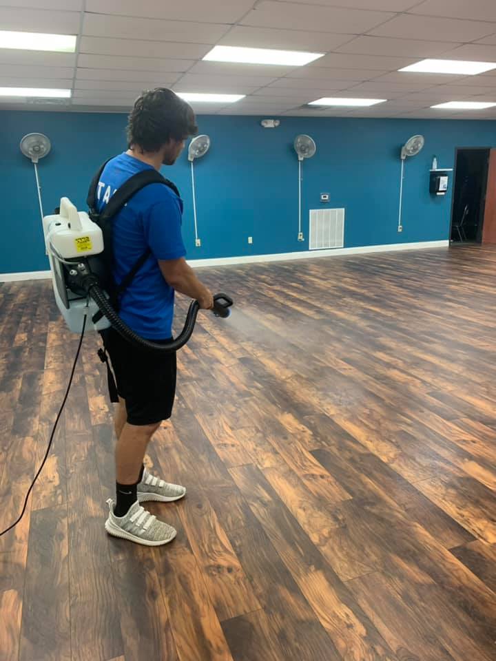 Barnwell YMCA staff using a disinfectant fogger to clean group exercise class gym.